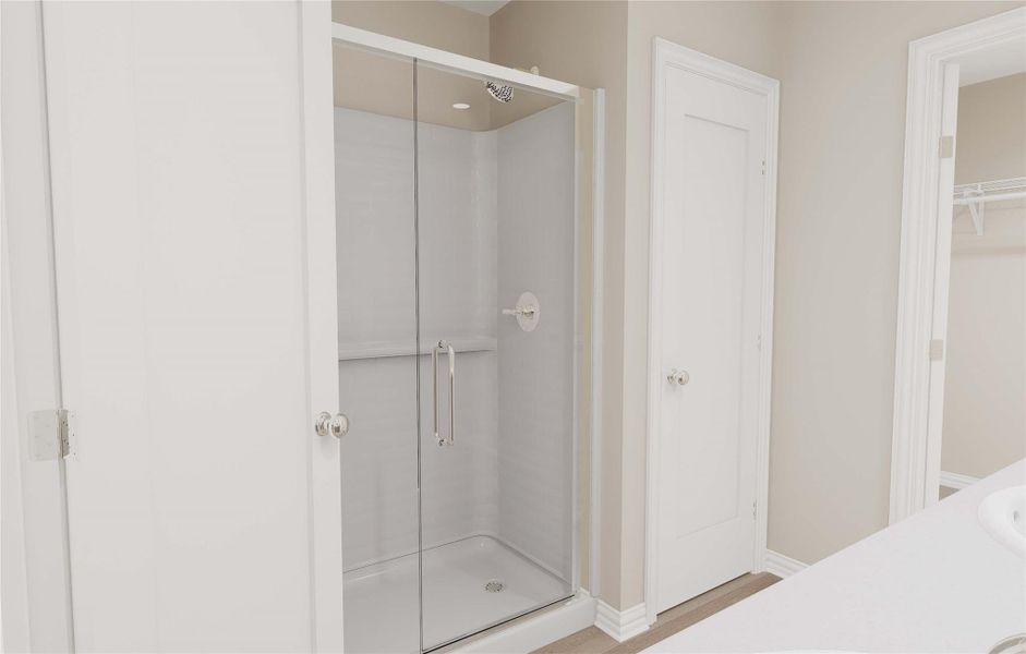 Bathroom with a shower stall and baseboards