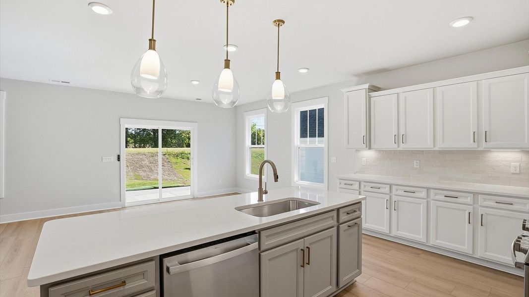Memorable meals begin in this vibrant kitchen with pendant lighting and a thoughtfully designed island Memorable meals begin in this vibrant kitchen with pendant lighting and a thoughtfully designed island