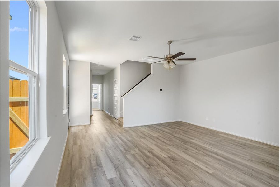 The living room gets plenty of natural light through large windows.