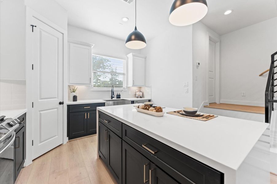 Sleek and modern bathroom featuring a double vanity with dark cabinetry, elegant black fixtures, and large mirrors enhanced by stylish lighting.