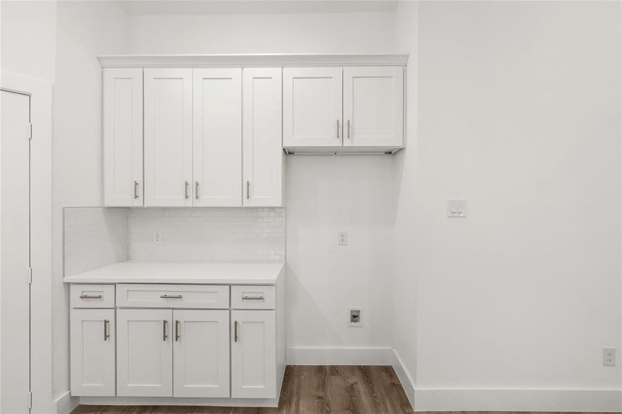 Washroom featuring cabinets and dark wood-type flooring