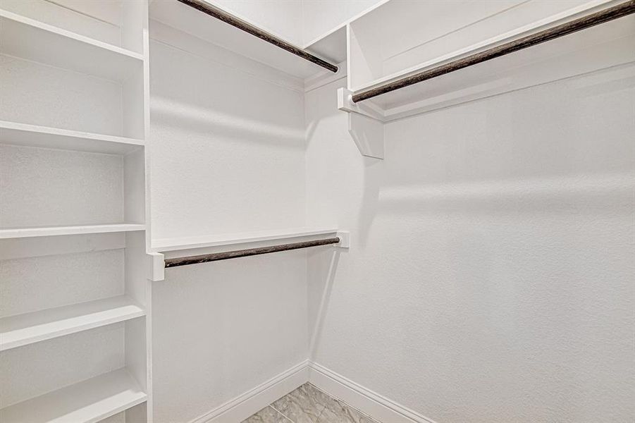 Spacious closet with light tile patterned floors