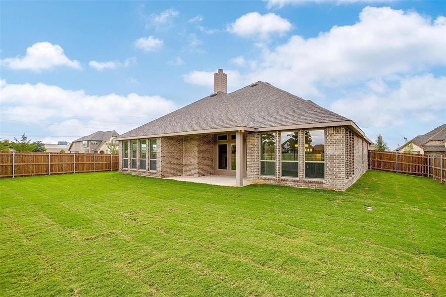 Back of house with a yard and a patio