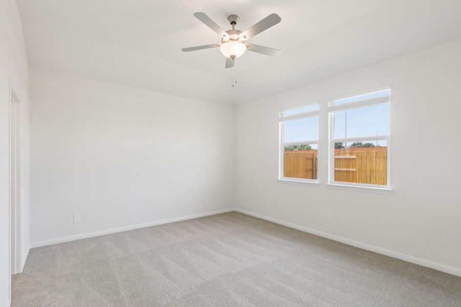 Empty room featuring light colored carpet and ceiling fan Empty room featuring light colored carpet and ceiling fan