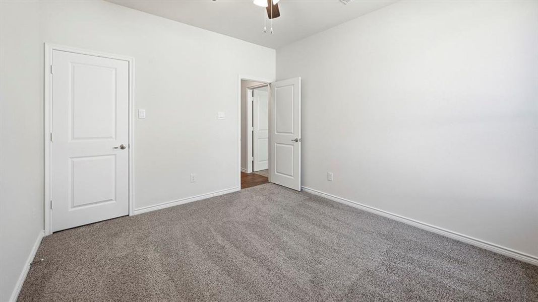Unfurnished bedroom featuring carpet and a ceiling fan