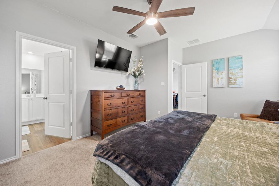 A well-appointed primary bedroom overlooks greenbelt with lake behind home. A well-appointed primary bedroom overlooks greenbelt with lake behind home.