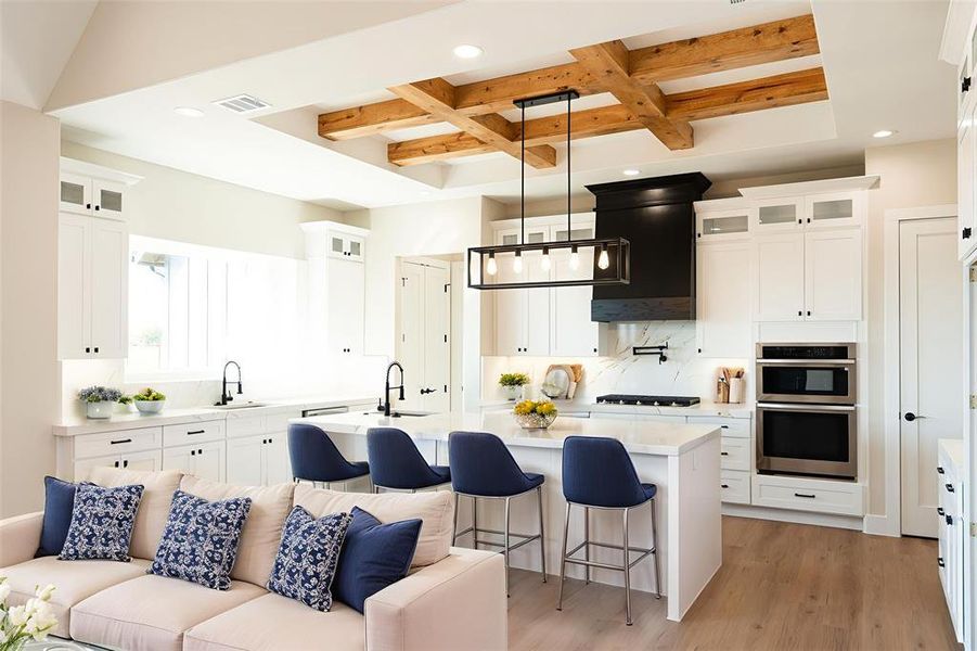 Kitchen featuring glass insert cabinets, a kitchen bar, coffered ceiling, beam ceiling, and tasteful backsplash