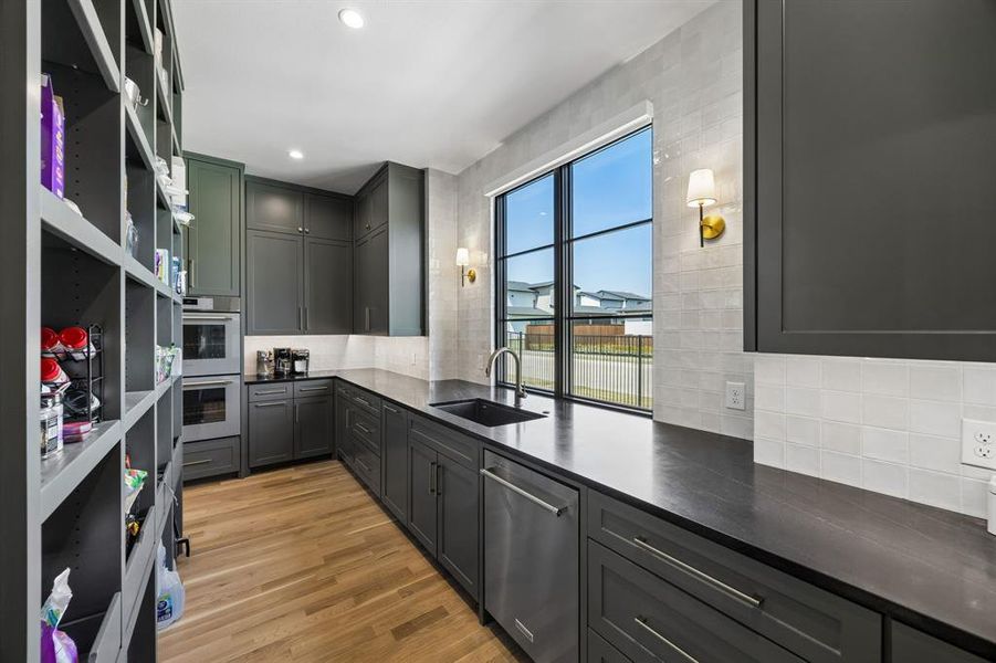 Working pantry features the convenience of double ovens, a 2nd farmhouse sink, and the practicality of having ample storage space throughout.