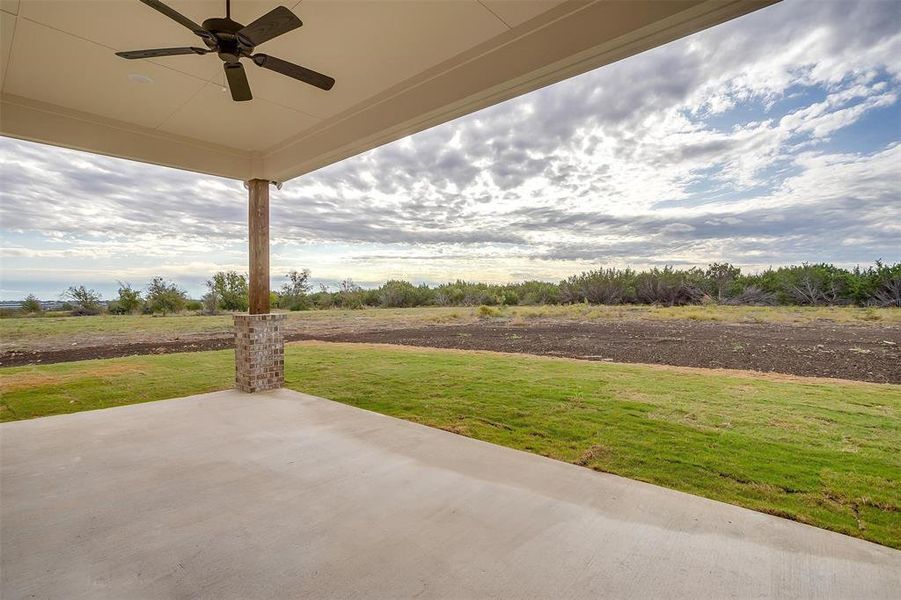 Nice sized covered patio overlooks the back acreage.