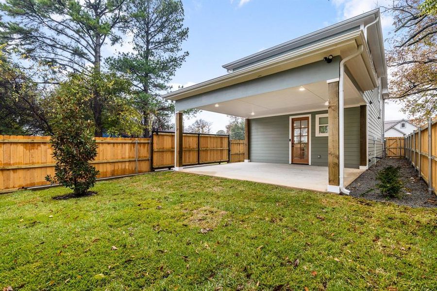 Back of property featuring a lawn and a patio area