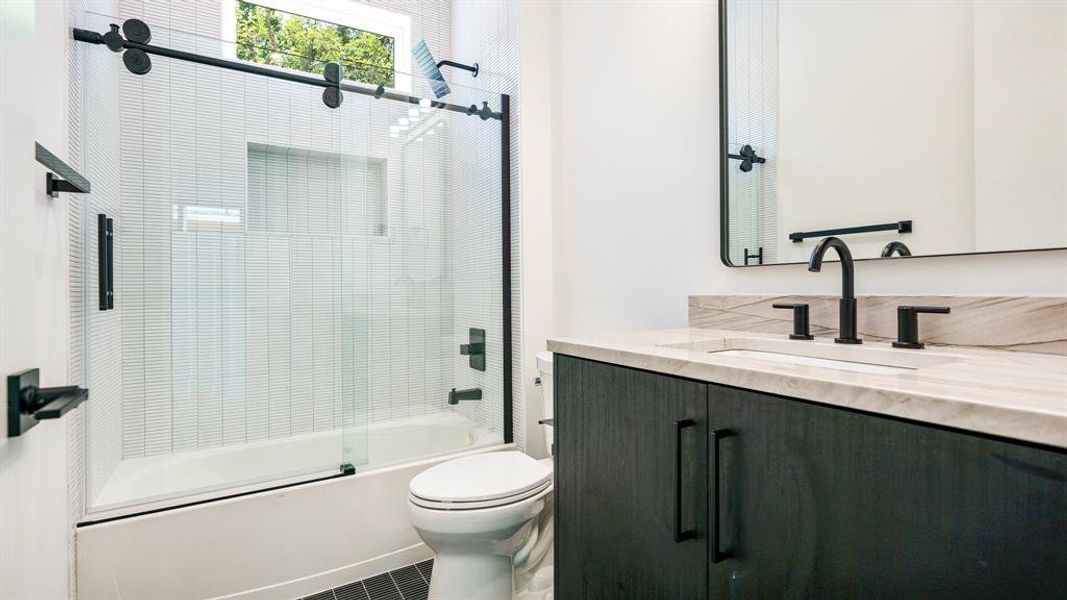 Full bathroom with combined bath / shower with glass door, vanity, and toilet