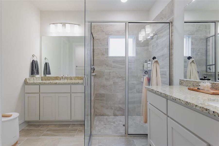 Frameless glass shower enclosure with a tiled interior, featuring a built-in shelf and a window
