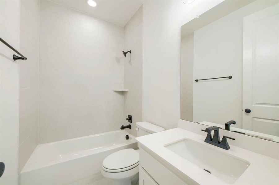 Modern bathroom with a white vanity, integrated sink, and dark bronze faucet Modern bathroom with a white vanity, integrated sink, and dark bronze faucet