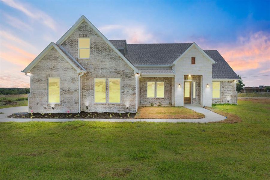 View of front of house featuring brick siding, a shingled roof, and a yard View of front of house featuring brick siding, a shingled roof, and a yard