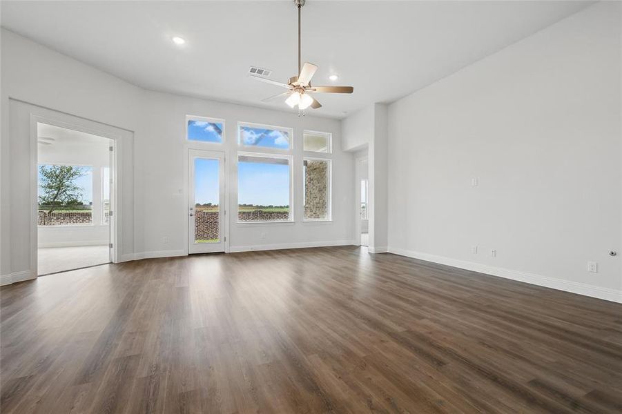 Unfurnished living room with a ceiling fan, baseboards, recessed lighting, dark wood-type flooring, and visible vents