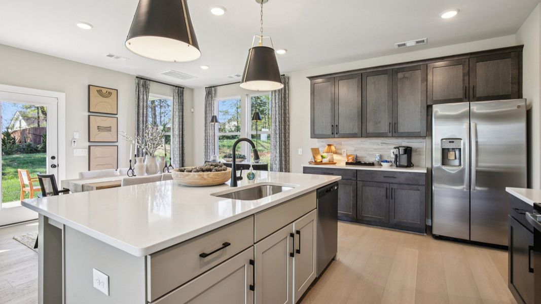 Kitchen with quartz countertops and dark cabinetry