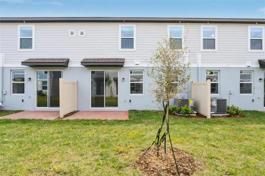 Exterior details and patio area of a home in The Meadow at Crossprairie Townes, St. Cloud (Image 3).