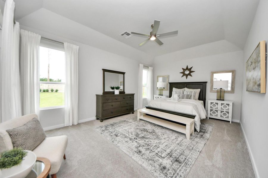 Come and unwind after a long day in this magnificent primary suite! This spacious room features plush carpet, warm paint, high ceilings and large windows with privacy blinds. Sample photo of completed home with similar floor plan. Actual colors and selections may vary.