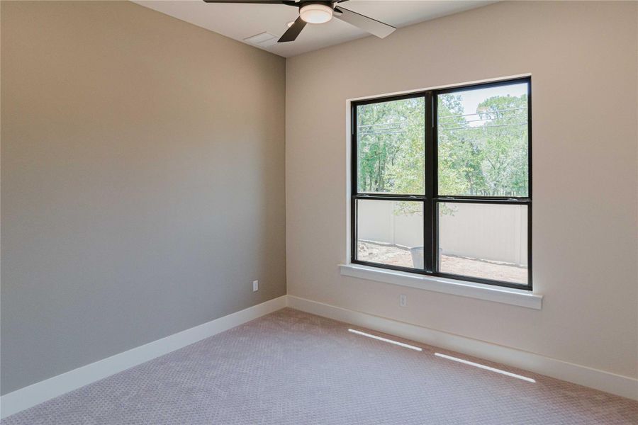 Unfurnished room with light colored carpet and ceiling fan