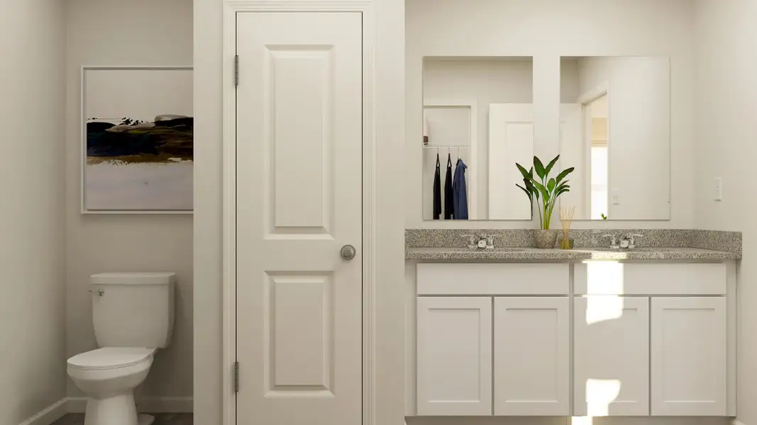 A bathroom with white cabinets.