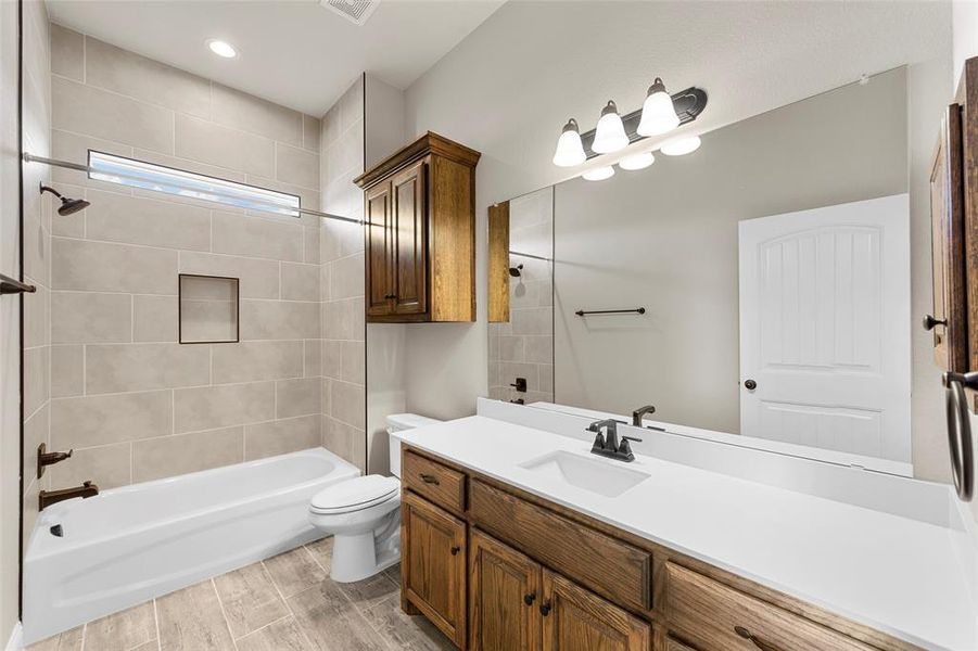 Full bathroom featuring vanity, toilet, hardwood / wood-style flooring, and tiled shower / bath