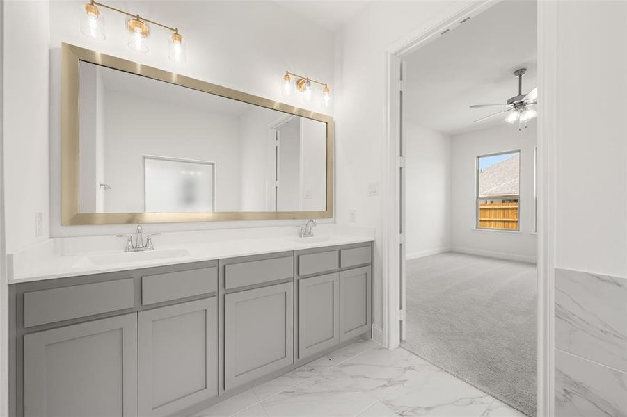 Bathroom with double vanity, marble finish floors, and ceiling fan Bathroom with double vanity, marble finish floors, and ceiling fan