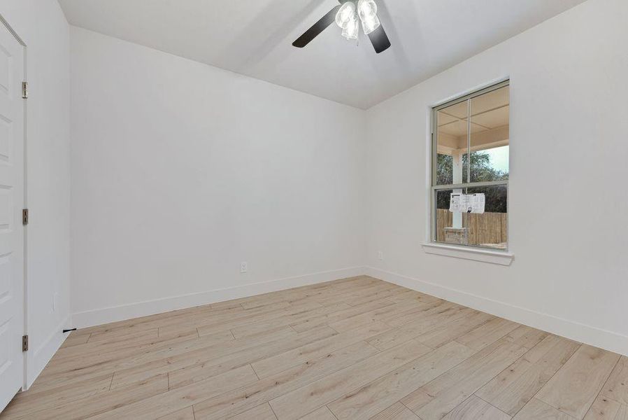 Spare room with light wood finished floors and ceiling fan