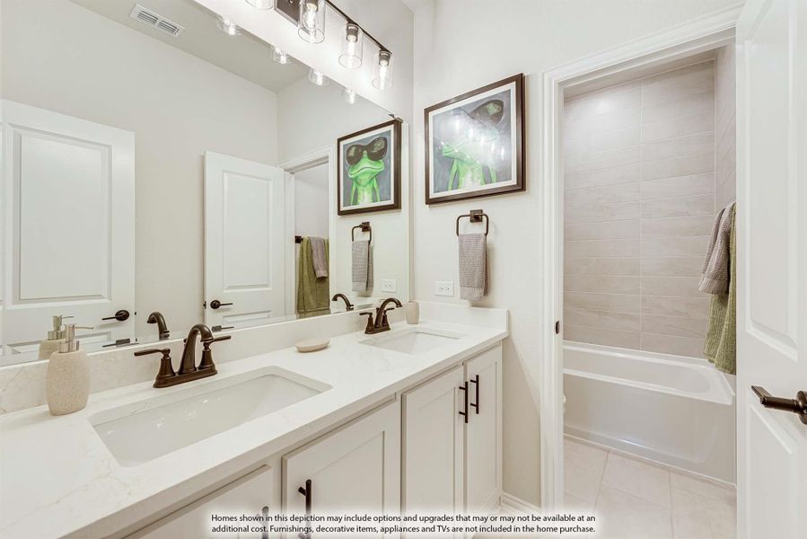 Bathroom with double sink vanity, white cabinets, large mirror, and tiled shower-tub combo with bronze fixtures