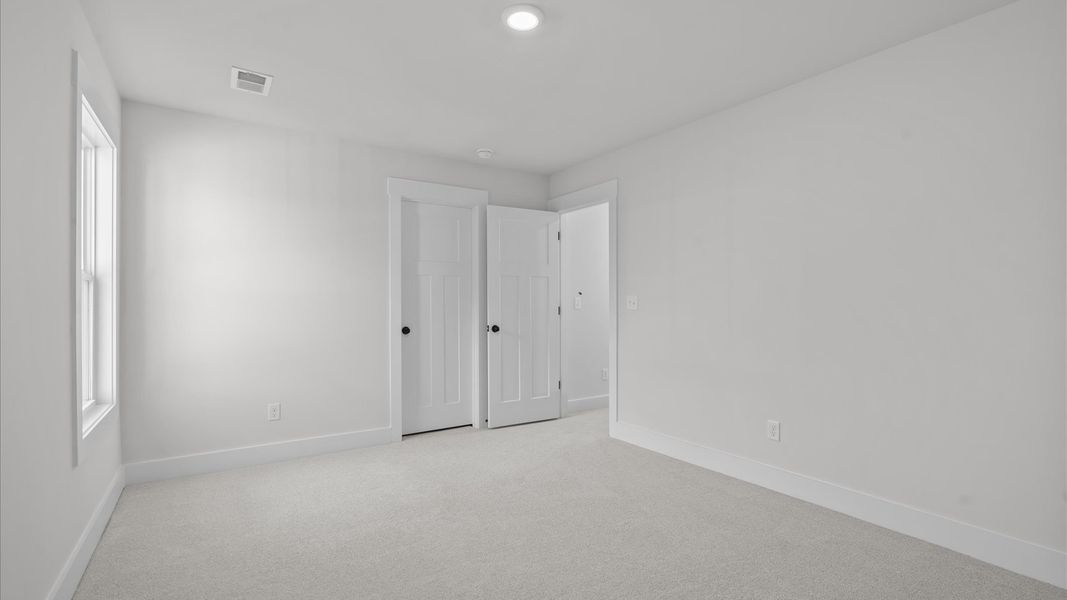 Accomplished design in this restful bedroom featuring plush carpet and oversized window views Accomplished design in this restful bedroom featuring plush carpet and oversized window views