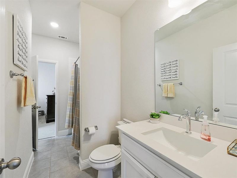 Bathroom featuring toilet, tile patterned floors, and vanity