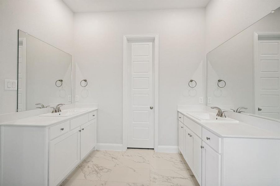 Bathroom featuring dual white vanities with inset sinks, brushed nickel faucets, and expansive wall-mounted mirrors