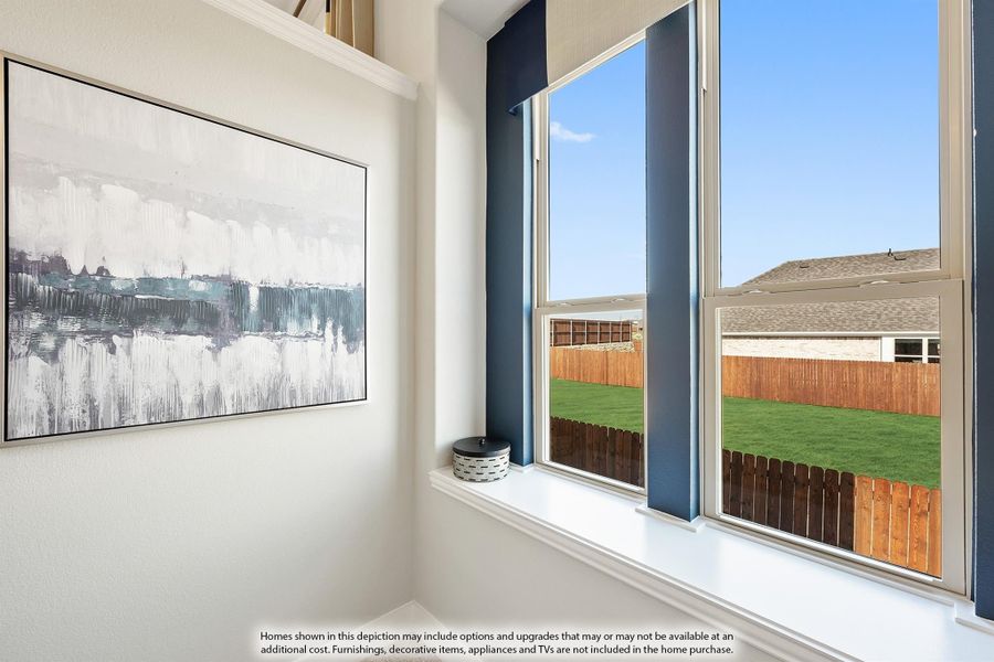Large window with view of fenced backyard and green lawn, beside abstract wall art on white wall Large window with view of fenced backyard and green lawn, beside abstract wall art on white wall
