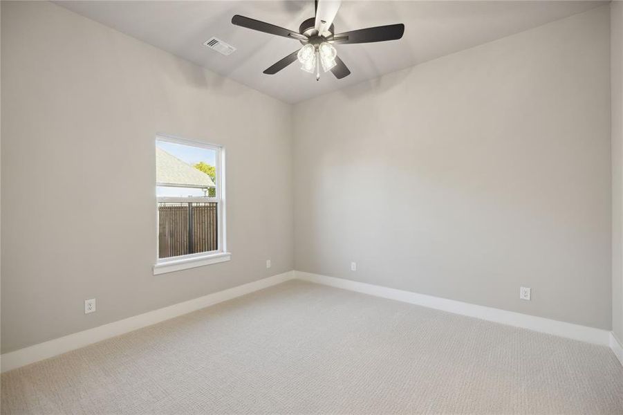 Carpeted spare room featuring ceiling fan