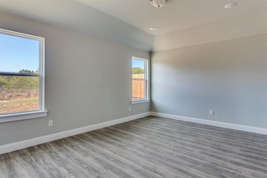 Spare room with wood finished floors, recessed lighting, and lofted ceiling