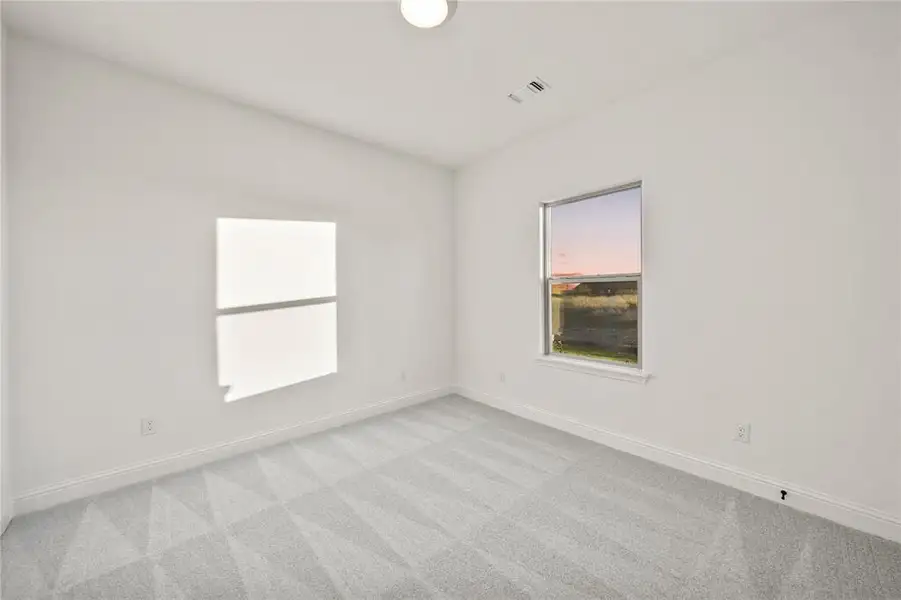 Unfurnished room with baseboards and light colored carpet