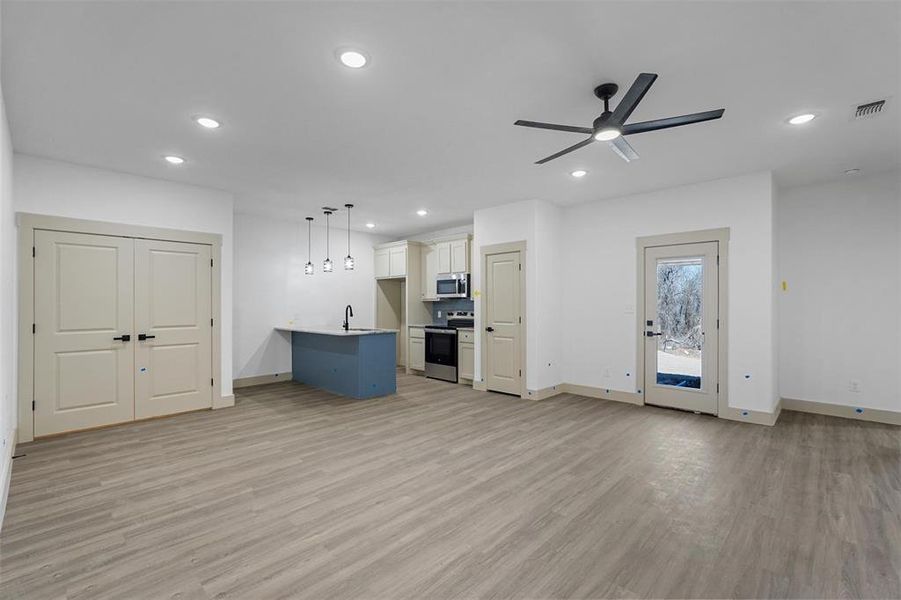 Unfurnished living room featuring recessed lighting, light wood-type flooring, and visible vents