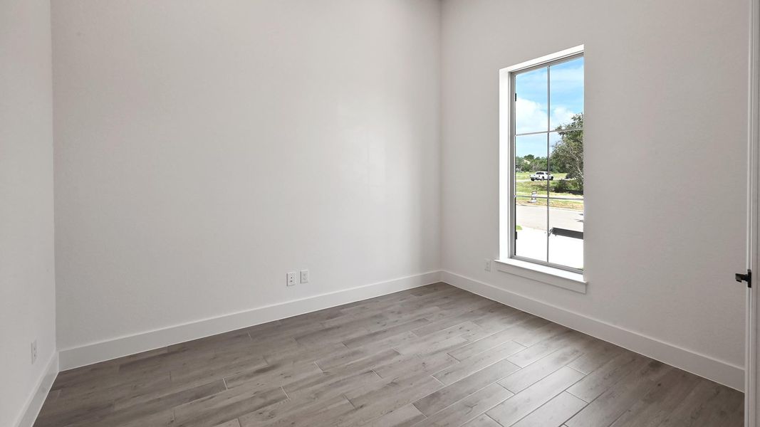 Empty room featuring plenty of natural light and wood finished floors Empty room featuring plenty of natural light and wood finished floors
