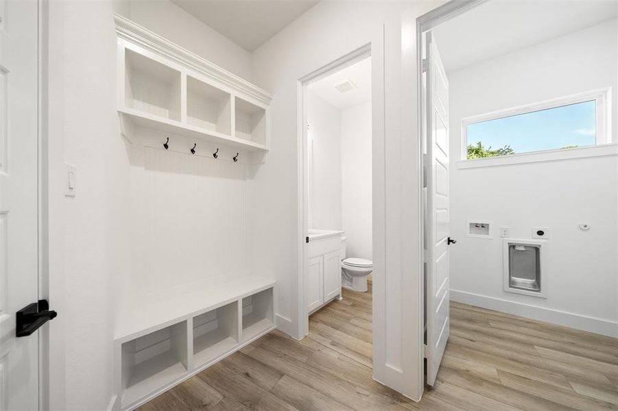 Mudroom with light wood-type flooring and baseboards