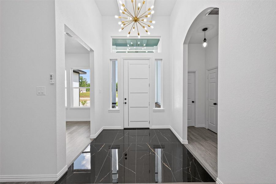 Grand entryway featuring soaring ceilings, elegant architectural details, and an inviting first impression.