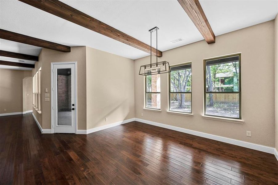 Unfurnished room with beamed ceiling and hardwood / wood-style flooring