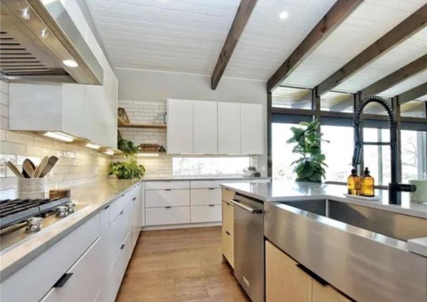 Kitchen featuring open shelves, range hood, light wood-type flooring, beamed ceiling, and stainless steel appliances Kitchen featuring open shelves, range hood, light wood-type flooring, beamed ceiling, and stainless steel appliances