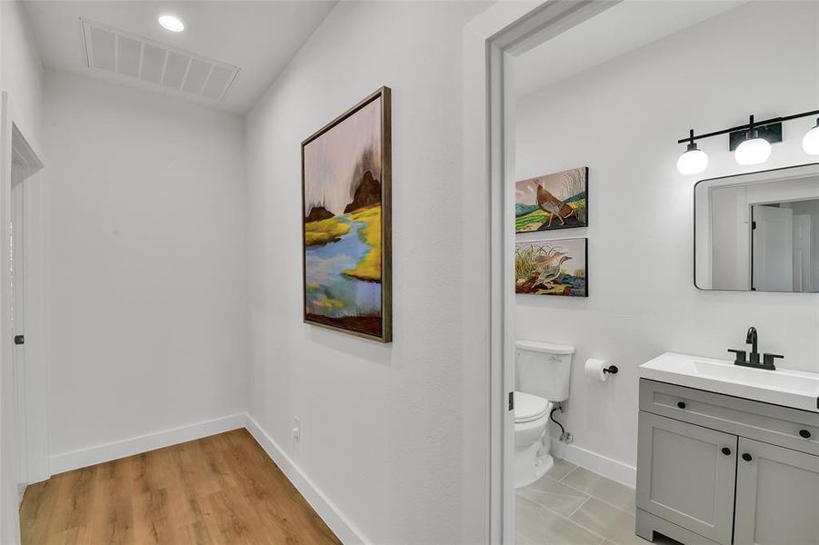 Bathroom featuring wood-style flooring, vanity, and toilet