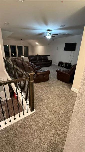 Living area with carpet flooring and a ceiling fan