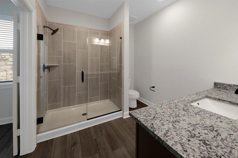 The en-suite master bath features an oversized shower and beautiful granite countertops.