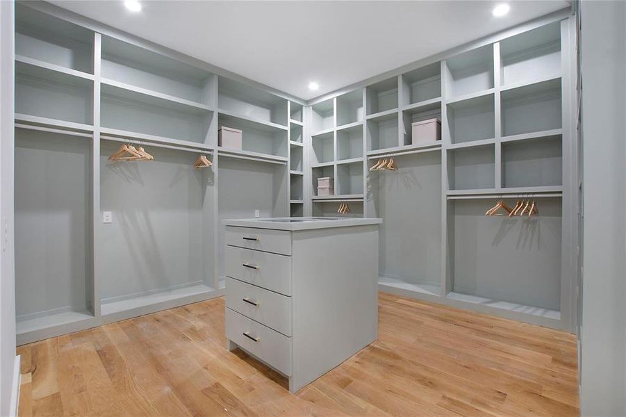 Walk in closet with light wood-style floors Walk in closet with light wood-style floors