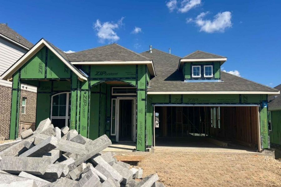 Unfinished property featuring a shingled roof and an attached garage Unfinished property featuring a shingled roof and an attached garage