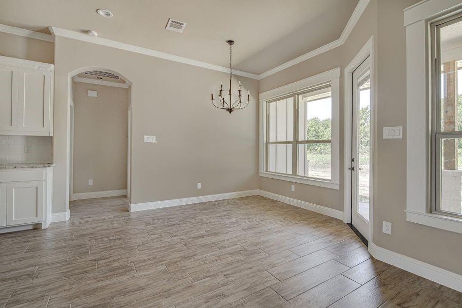 Unfurnished dining area with an inviting chandelier and crown molding