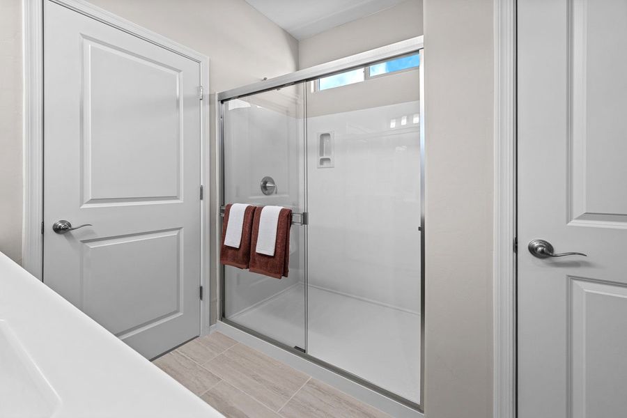 Walk-in shower with cultured marble surround at primary bath Walk-in shower with cultured marble surround at primary bath