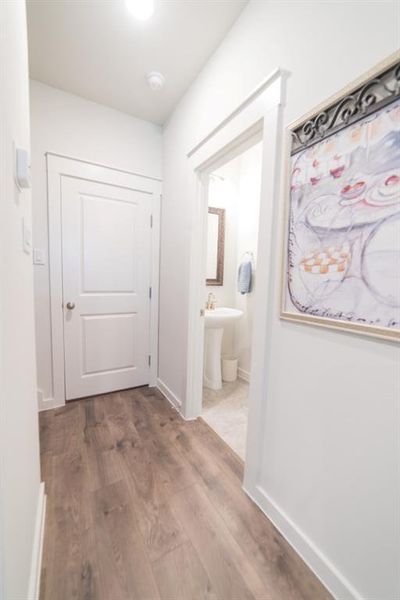 Corridor featuring light wood-type flooring and baseboards
