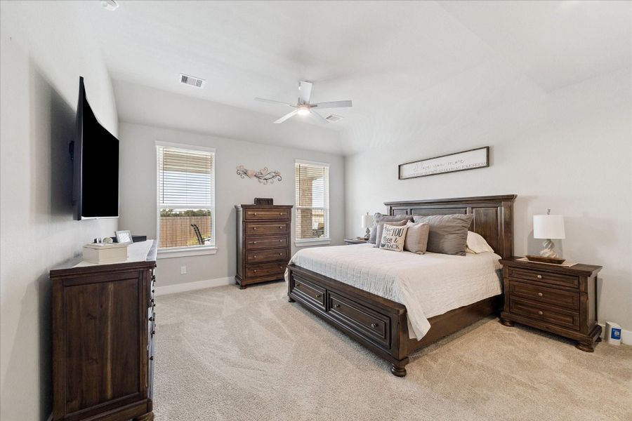 Bright, spacious bedroom with neutral tones, wood furnishings, and soft carpet. Bright, spacious bedroom with neutral tones, wood furnishings, and soft carpet.